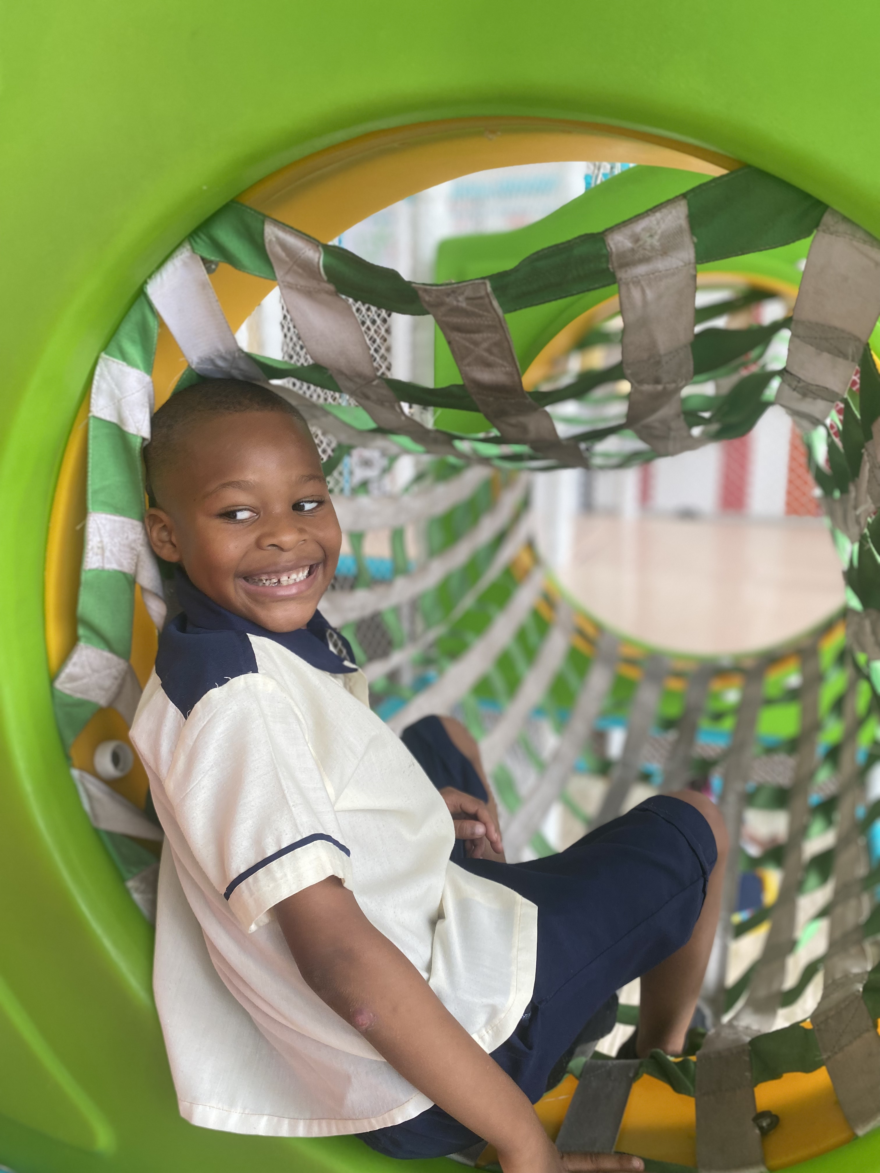 Criança no túnel do parque infantil